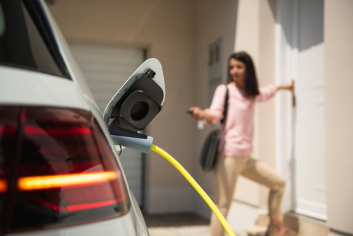 Photo by husjur02 shows a charge@home scenario where a woman is charging her electrical car at home; licensed from https://www.shutterstock.com/de/image-photo/close-electric-car-charger-female-silhouette-1812967390