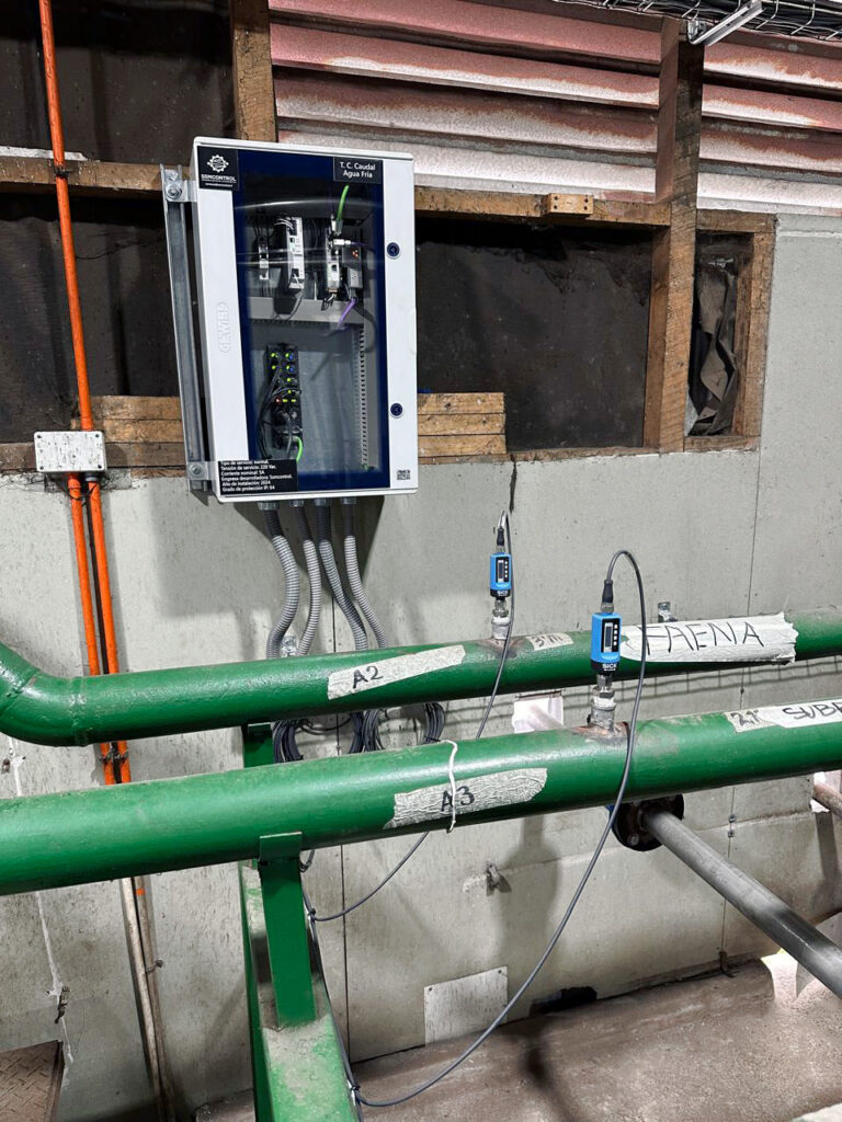 Close-up of green pipes with installed sensors and a control cabinet at Frigosorno, used for monitoring water and energy consumption via Proficloud.io.